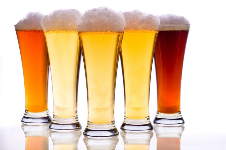 Close-up of beer glasses against white background