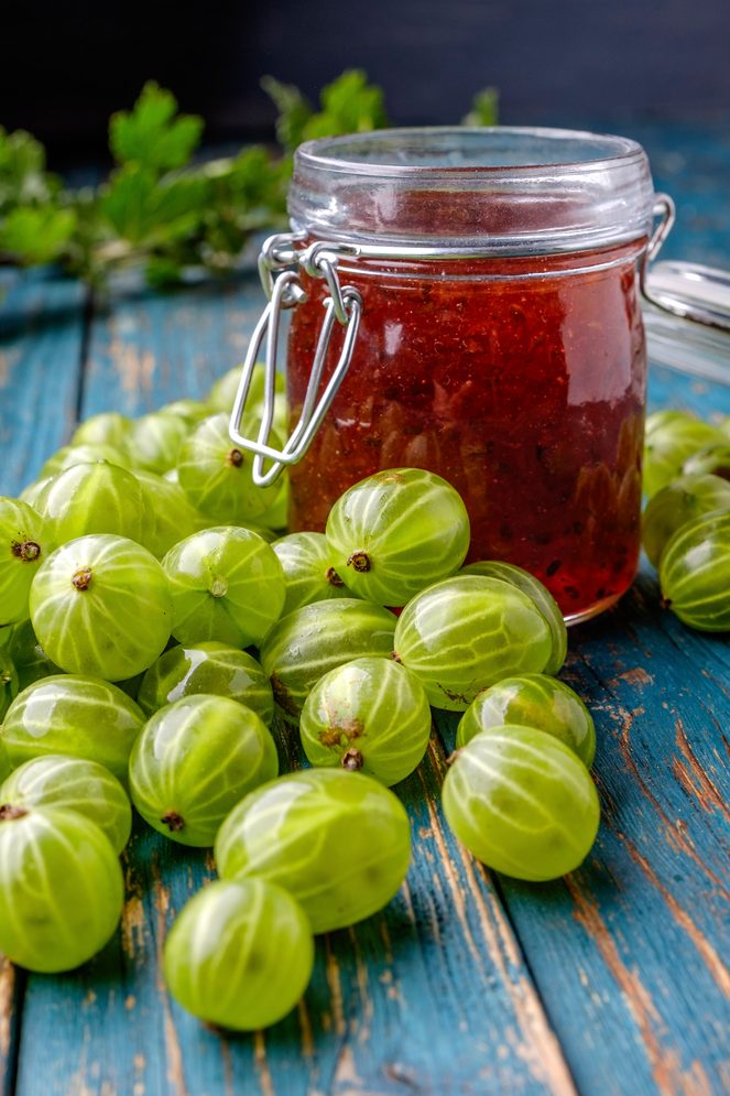 Jar Of Gooseberry Jam On A Wooden Table.